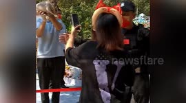 Tourist attempts to push through police cordon to take pictures of lion cub in southern China