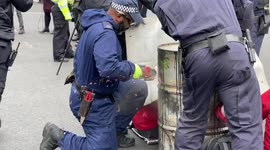 Police use specialists’ tools to cut loose protesters from barrels they lock themselves to in front of Downing Street