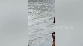 Locals move jeepney trapped in flood during Tropical Storm Kompasu in the Philippines