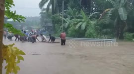 Residents use bamboo raft for motorcycle riders to cross floods in the Philippines