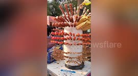 大爷冰糖葫芦摊上围满小蜜蜂