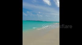 A traveler shows how people litter on the beach in the Maldives