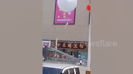 Woman floating via giant balloon captivates mallgoers in China
