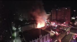 Drone footage shows a strip of shops in New York's Harlem district engulfed in flames