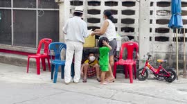 Kid chills on hammock underneath stand selling street food
