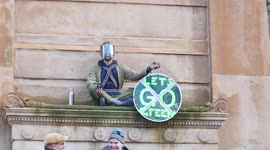 Small Child With Gas Mask Sits on Statue During COP26 Friday Protest