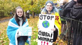 Two young girl Protestors hold signs at COP26 Protests at Glasgow 2021 United Kingdom as Protestors Chant