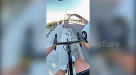 Watch as daredevil cycle across bridge arch in dangerous stunt