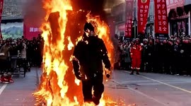 Fireman walks out of flaming cage to demonstrate fire-resistant suit in China