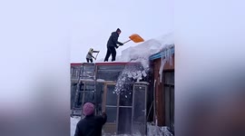 Man clings onto roof after snowdrift nearly pushes him off in China