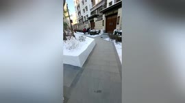 Cleaners sweep snow into neat blocks to clear paths at residential community in China