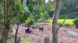 Motorcycles carrying vaccines ride through swollen river to reach remove village in Thailand