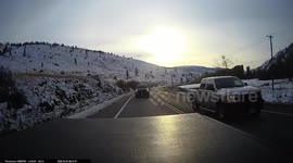 Rear cam shot of truck passing on curve over double solid lines.