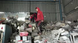 Palestinians collect damaged batteries in a store in Jabalia, northern Gaza Strip