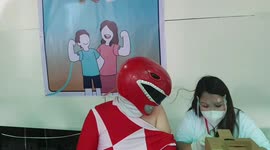 Superhero fan receives Covid-19 Omicron booster jab dressed as red power ranger in the Philippines