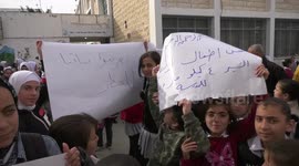 Palestinian students hold  banners during a protest at their school run by the United Nations Relief and Works Agency (UNRWA) in the West Bank city of Hebron