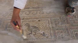Workers restore a Byzantine church mosaic on the floor of a church in Khan Younis, Gaza
