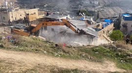 An Israeli bulldozer demolishes a house in Jabal al-Mukaber