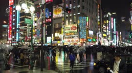 Commuters cross road during rain in Tokyo, Japan