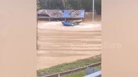 Boats perform dangerous stunts in flooded Malaysian village amidst deaths