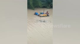 Indonesia flood victims float on makeshift raft made out of water jugs