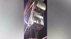 Ferris wheel gondola flips upside down with kids inside at funfair in Malaysia