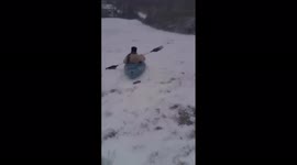 Girl enjoys kayaking on snow-covered yard in Illinois
