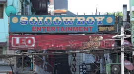 Unlit neon signs on Soi Cowboy red light district in Bangkok, Thailand