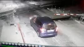 The car almost collided with the train, trying to pass the railway crossing with the barrier closed