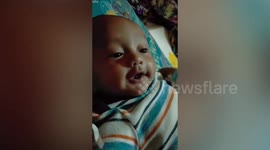 Smart two-month-old baby boy appears to talk to parents during playtime
