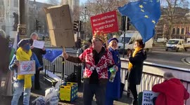 A protester offers cheese and wine to passers-by outside Parliament as Boris Johnson faces pressure over lockdown parties, London, UK