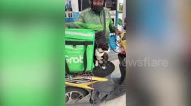 Cute cat joins delivery food rider owner while taking orders for customers