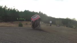 Rally car rolls multiple times after losing control at a little jump