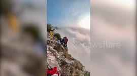 Base jumpers launch themselves from 1,000-meter high cliff into cloudy abyss