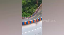 Determined cyclist pedals on uphill slippery road after heavy rain