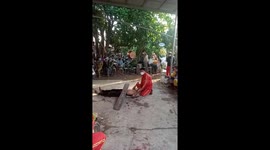 Motorbike with 4 men on board rides over man lying on glass in Vietnam