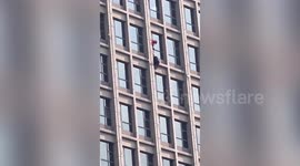 Fireman rescues man hanging upside down out of 13th-floor window in northern China