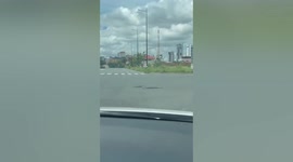 Huge snake holds up traffic while crossing road in Cambodia