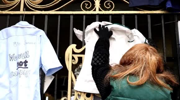 Nurse's hang NHS uniforms on gates of Manchester Mayor Andy Burnham's office