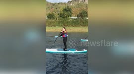 Family tries their hardest to keep their balance on paddleboards before FACE-PLANTING into water