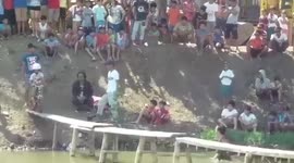 Biker kid pedals across narrow wooden bridge in the Philippines