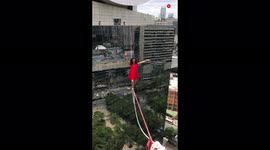 Brazilian yoga trainer incredibly walks highline above busy São Paulo street