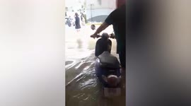 Residents push up car from flooded apartment block parking lot in Thailand