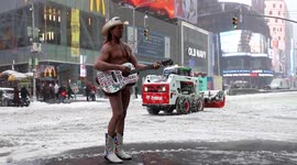 Times Square’s Naked Cowboy performs and poses for pictures as snow falls in New York City