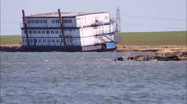 Strong winds hamper recovery of an unmanned barge/ship that drifted into a creek in Kent, UK