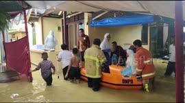 Trapped in Indonesian flood, bride and groom are evacuated on a rubber boat