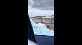 Terrifying moment a huge wave nearly drags Greek dock workers into the sea