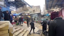 Palestinians walk in a street flooded by rain water at a market in Jerusalem old city.