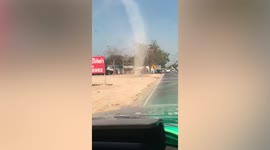 Dust devil tornado tears along roadside in Thailand