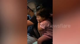 Cute toddler giggles while buying ice cream at drive-thru in Malaysia